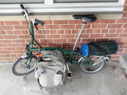 Packraft on Brompton bicycle with backpack containing lifejacket and folding paddle.