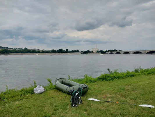 Packraft, backpack, and folding bicycle on Virginia shoreline.